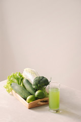 Vegan diet food. Detox drinks. Freshly squeezed juices and smoothies from vegetables. On white background, wooden tray, ingredients. Copy space