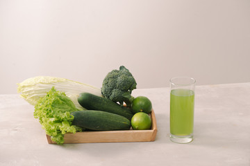 Vegan diet food. Detox drinks. Freshly squeezed juices and smoothies from vegetables. On white background, wooden tray, ingredients. Copy space