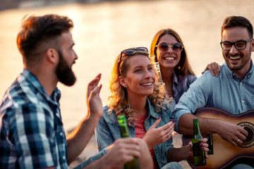 Friends are camping and playing guitar