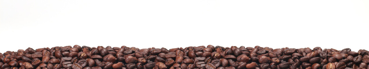 Fototapeta premium Roasted coffee beans, dark Roast coffee background. Closeup pile of coffee beans on white background, space for text
