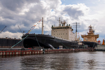 Big ship near the pier on the background of dramatic sky