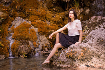Beautiful girl posing in river, fairy fast forest in autumn.  Beauty, fashion. Spa, healthcare. Tropical vacation. Natural pool.