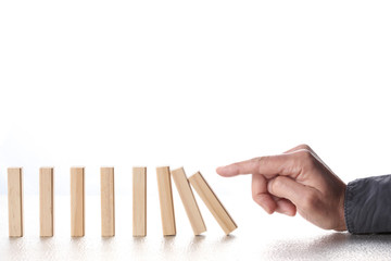male finger pushing domino blocks with falling chain reaction isolate on white background with copy space for your text