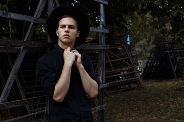attractive guy in a hat on the street, in black, hat