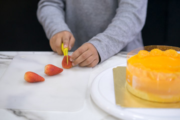 hand of asia kid boy making a cake