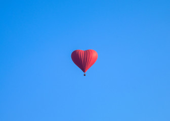 Colorful hot air heart shape balloons flying in blue sky