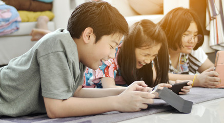 Asian boy and girl playing game on mobile phone together with smile face.