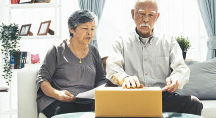 Asian senior man and woman open box with smile face.