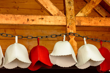 Foil hats for the sauna hang on the chain for sale on the market.