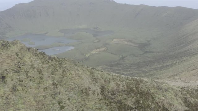 Aerial view of volcanic crater (Caldeirao) with a beautiful lake on the top of Corvo island. Azores islands, Portugal.