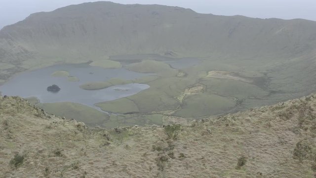 Aerial view of volcanic crater (Caldeirao) with a beautiful lake on the top of Corvo island. Azores islands, Portugal.