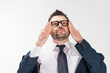 chubby man in formal wear putting on glasses on white