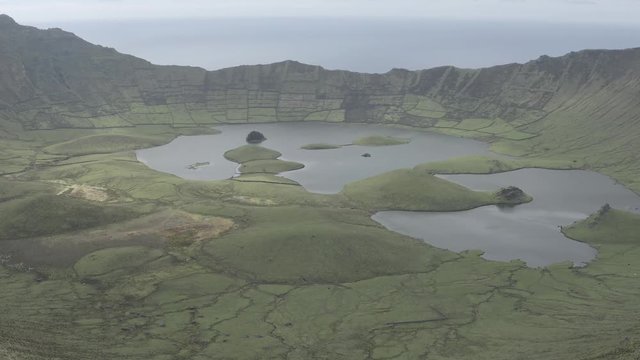 Aerial view of volcanic crater (Caldeirao) with a beautiful lake on the top of Corvo island. Azores islands, Portugal.
