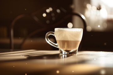 Italian typical cappuccino in a glass cup on a grey table