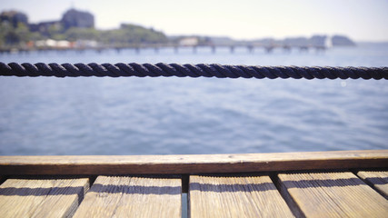 Naklejka premium Wooden pier and rope fence at the sea close-up