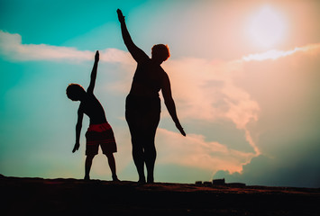 Silhouette of family play at sunset sky