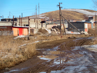 Buildings on the outskirts of the city. Ust-Kamenogorsk (Kazakhstan). Dirt road. Spring landscape
