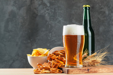 Lager beer and snacks on stone table. Cracker, chips side view