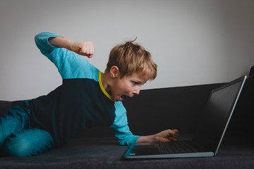 agressive child with laptop at home, kid wrong reaction to failure