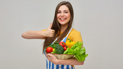 chef woman wearing striped apron holding vegetables