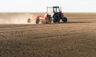  Farmer with tractor seeding sowing crops at agricultural field