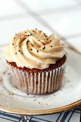 Chocolate homemade cupcakes with earl gray tea buttercream frosting on white plate. Dessert bakery style food photo 