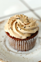 Chocolate homemade cupcakes with earl gray tea buttercream frosting on white plate. Dessert bakery style food photo 