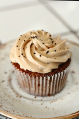 Chocolate homemade cupcakes with earl gray tea buttercream frosting on white plate. Dessert bakery style food photo 