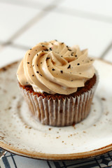 Chocolate homemade cupcakes with earl gray tea buttercream frosting on white plate. Dessert bakery style food photo 