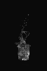 Glass of drinking water. From a glass of water splashes on a dark background.