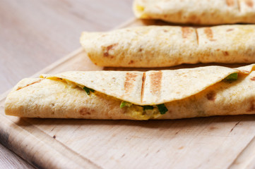 Corn tortilla rolls on cutting board