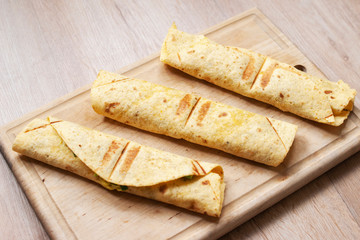 Corn tortilla rolls on cutting board