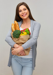 happy woman with toothy smile holding shopping bag with vegan food.