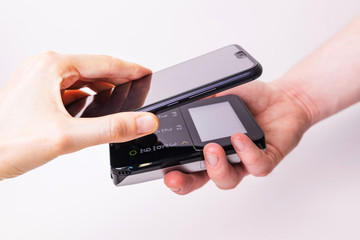 Pos terminal and hand with a smartphone on a white background. Banking equipment. Acquiring. Acceptance of bank credit cards. Contactless payment.