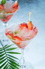 Strawberry lemonade or alcoholic cocktail with ice syrup soda and mint leaves on bar table.