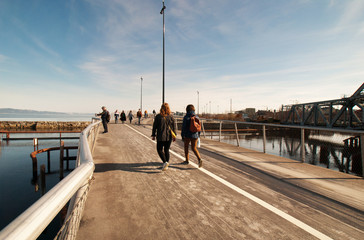 People walking on bridge at sunset, Trondheim, Norway