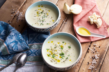 Cream soup with cauliflower, onion and oil. Dieting. Organic. Homemade. Wooden table.