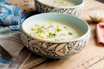 Cream soup with cauliflower, onion and oil. Dieting. Organic. Homemade. Wooden table.