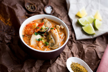 Soup with king prawns, seafoods, mussels. Lime and garlic. Spices and pepper. Top view. Diet. Dinner. Homemade
