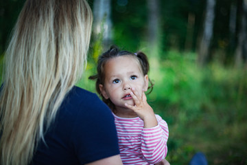 Beautiful woman and her little daughter having fun in the meadow, single mother concept, copy space