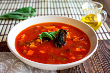 Tomato soup with mussels and seafoods. Oil. Homemade. Dinner. Basil. Traditional.