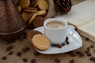A cup of coffee. While reading a book, have a cup of coffee with cookies. Stop for a minute, coffee is a pleasure.