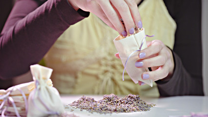 Filling small bag with lavender seeds