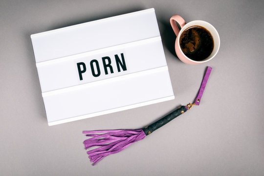 Porn. Text in light box. Pink coffee mug on gray background
