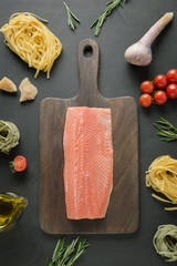 Ingredients for pasta tagliatelle with trout on chopping board. View from above.