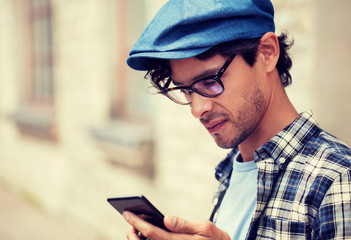 leisure, technology, communication and people concept - close up of hipster man texting message on smartphone