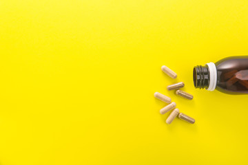 Herbal medical capsule on a yellow