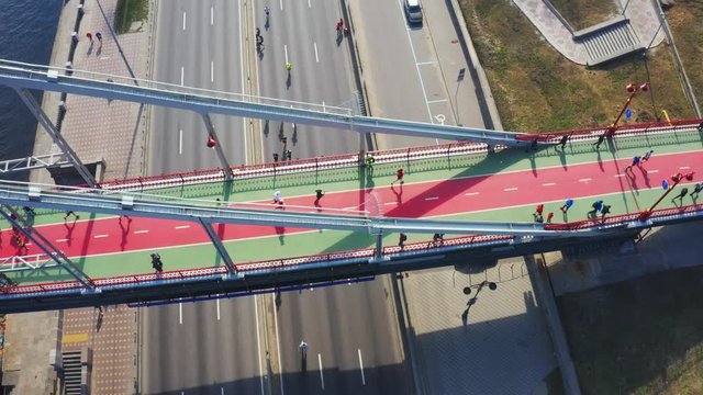 Participants of the marathon run on a pedestrian bridge. Aerial footage
