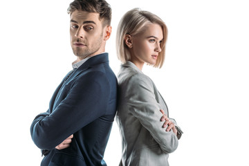 attractive businesswoman and good-looking businessman standing back to back with crossed arms isolated on white
