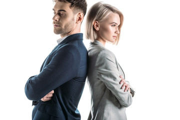 pretty businesswoman and handsome businessman standing back to back with crossed arms isolated on white